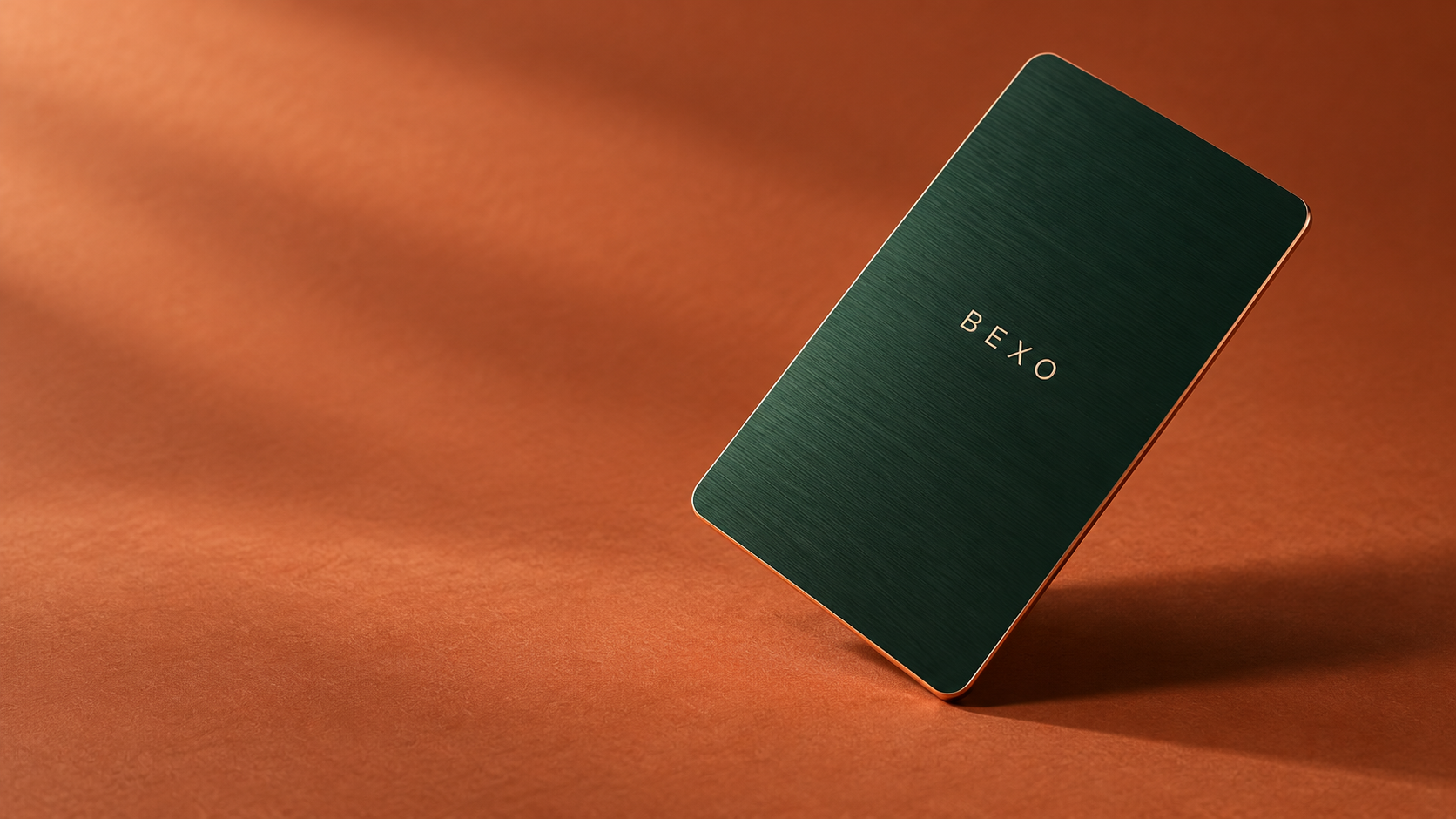 BEXO card concept in forest green and copper on a terracotta studio surface
